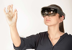 Junge Frau mit VR-Brille und Handbewegung 