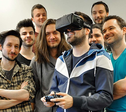Studierendengruppe, einer davon hat eine VR Brille und Fernbedienung in der Hand