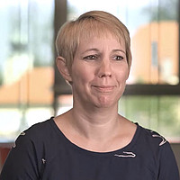 Person vor Hintergrund mit gelben Gebäuden 