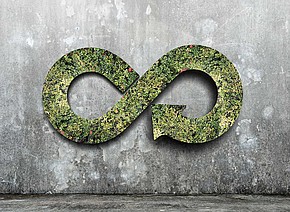 Offene grüne Acht mit Pfeilende vor Betonwand