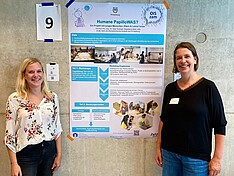 Magdalen Meikl und Geja Oostingh vom Studiengang Biomedizinische Analytik vor dem Projektposter. 