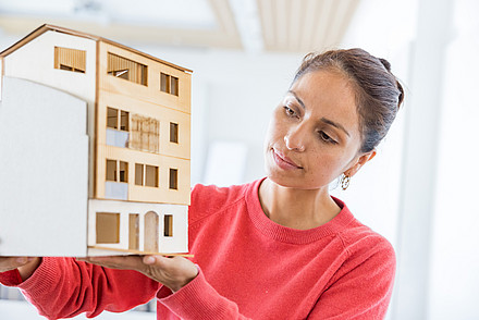 Green Building Studentin mit Holzmodell in der Hand