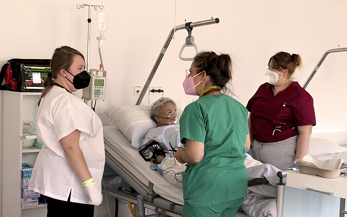 Senior Lecturer Christine Kern im Gespräch mit den Studierenden vor dem Simulationstraining am Nursing Anne Simulator.