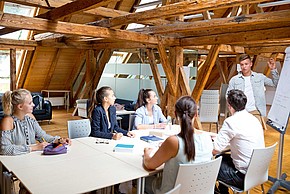 Studierendengruppe vor Flipchart am Dachboden der Meierei